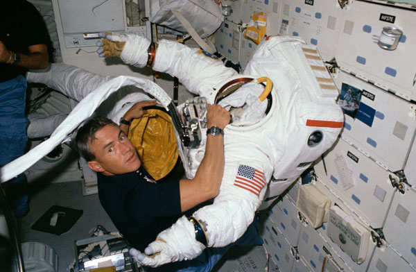 As 51I's ambitious space salvage operation took shape, one thing was certain: the mission would be EVA-intensive and RMS-intensive. Pictured on Discovery's middeck with one of the space suits, astronaut Bill Fisher would perform delicate electrical work on the crippled Leasat-3. Photo Credit: NASA
