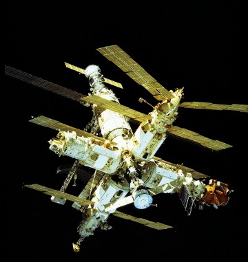 Mir, as viewed from Atlantis on STS-81. The orange-colored Docking Module (DM), at the end of the Kristall module, is visible at the right of the image. Photo Credit: NASA, via Joachim Becker/SpaceFacts.de