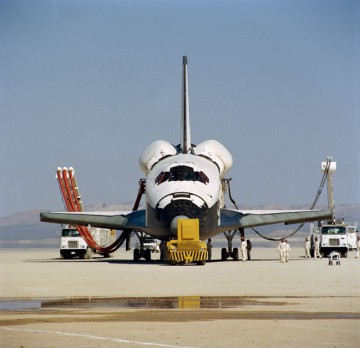 Servicing vehicles hook up cooling utilities to Columbia's aft compartment in the aftermath of the maiden landing of the shuttle. Photo Credit: NASA