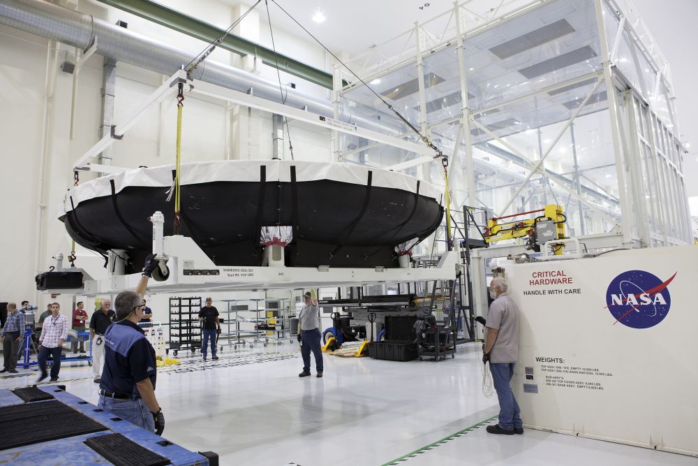 From NASA: "Inside the Neil Armstrong Operations and Checkout Building high bay at NASA’s Kennedy Space Center in Florida, technicians assist as a crane lifts the Orion heat shield for Exploration Mission 1 away from the base of its shipping container. The heat shield arrived aboard the agency’s Super Guppy aircraft at the Shuttle Landing Facility, managed and operated by Space Florida, from Lockheed Martin’s manufacturing facility near Denver. The Orion spacecraft will launch atop NASA’s Space Launch System rocket on EM-1, an uncrewed test flight, in 2018." Photo Credit: Photo credit: NASA/Dimitri Gerondidakis