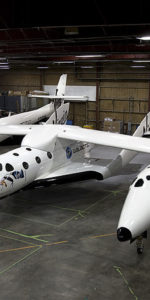 SpaceShipTwo resting under the Mothership White Knight Two inside a hangar in Mojave,Ca. USA. Photo Credit: Virgin Galactic/Mark Greenberg