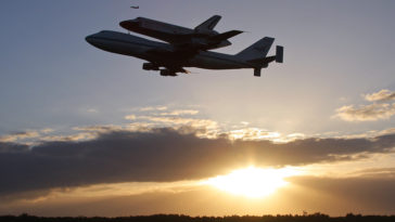 Space shuttle Discovery flying 'piggyback' atop a NASA 747 shuttle carrier aircraft, departing KSC this morning on her final flight, a one-way trip to the Smithsonian. Photo Credit: Mike Killian