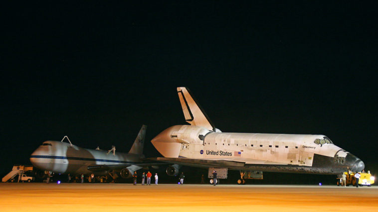 Shuttle Discovery passes by NASA's 747 Shuttle Carrier Aircraft early this morning, en route to the mate/demate structure where Discovery will be raised and mounted atop the 747 for her flight to the Smithsonian National Air and Space Museum this coming Tuesday. Photo Credit: Mike Killian