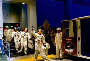 Like three extraterrestrials, clad in their bulky suits and protective yellow galoshes, the Apollo 11 astronauts - led by Neil Armstrong - departs the Operations and Checkout Building on launch morning. Photo Credit: NASA 