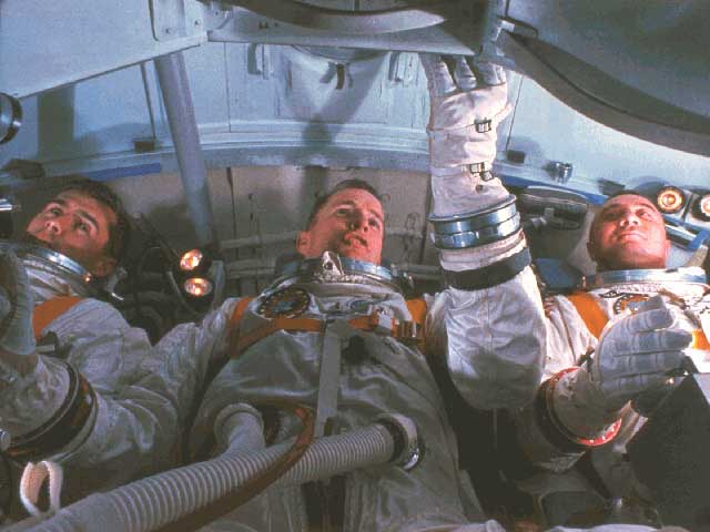 After the first cry from Roger Chaffee (left), even super-fit Ed White (center) was unable to even fully release the first bolt from the command module's inner hatch before he was overcome by fumes. The most likely origin of the fire was somewhere beneath the seat of Gus Grissom (right). Photo Credit: NASA