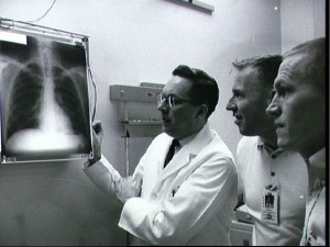 Gemini 7 prime crew members Frank Borman (right) and Jim Lovell (centre) undergo a pre-flight physical check. Their 14-day mission was the longest in history when it took place in December 1965. Photo Credit: NASA