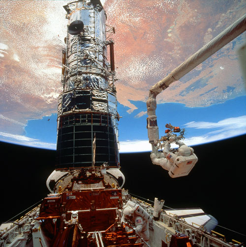 Story Musgrave works at the end of Endeavour's mechanical arm during activities to service the Hubble Space Telescope. Photo Credit: NASA
