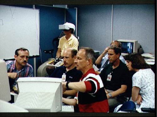 Claude Nicollier (foreground) participates in pre-launch training with his STS-61 crewmates, as Jeff Hoffman wears a virtual reality helmet. Photo Credit: NASA