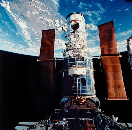 Grappled by the RMS mechanical arm, Hubble displays its glory to the Shuttle crew as it is anchored into the payload bay for five days of repairs and upgrades. Photo Credit: NASA