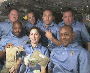 The STS-129 astronauts, including former ISS resident Nicole Stott (front center), display samples of their Thanksgiving food aboard Atlantis in November 2009. Photo Credit: NASA
