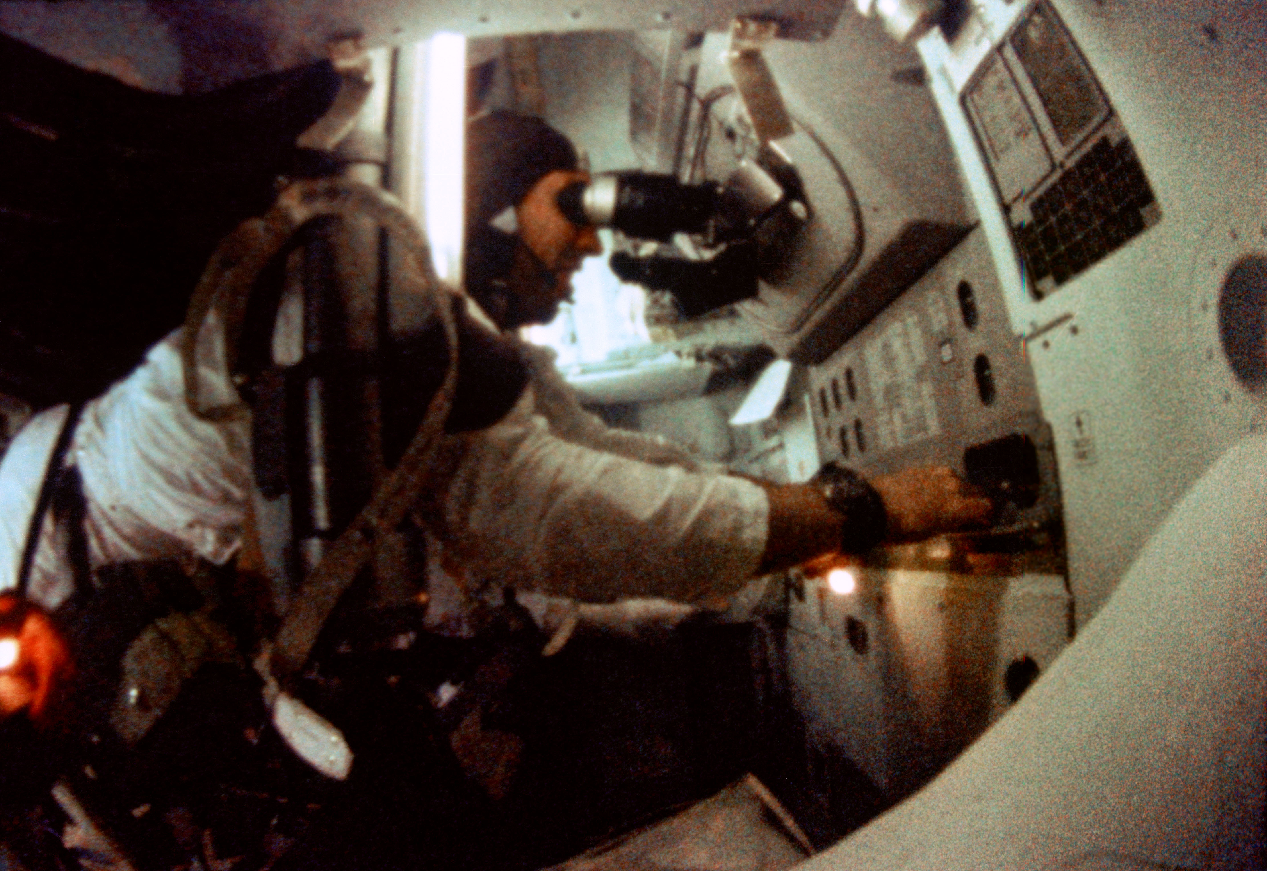 As the mission's senior pilot, one of Jim Lovell's responsibilities was taking star sightings and navigational measurements using the sextant and telescope. He is pictured at work in the command module's lower equipment bay. Photo Credit: NASA