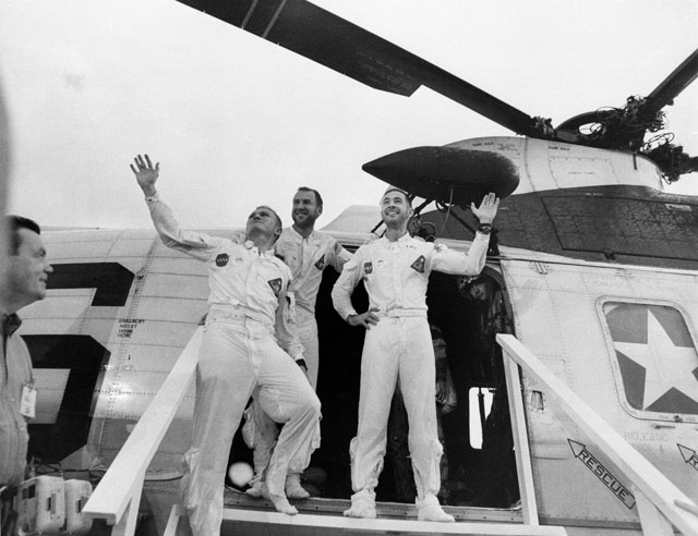 Frank Borman, Jim Lovell and Bill Anders wave to well-wishers at the door of the rescue helicopter after their recovery from their epic voyage. Photo Credit: NASA
