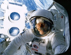 Jerry Ross peers inside Atlantis' crew cabin, with the Gamma Ray Observatory (GRO) behind him, during the first EVA of STS-37. Photo Credit: NASA