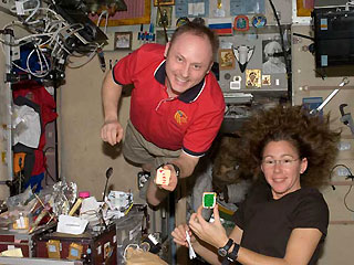 Expedition 18 astronauts Mike Fincke and Sandy Magnus display specially iced cookies for the Christmas holidays in 2008. Photo Credit: NASA