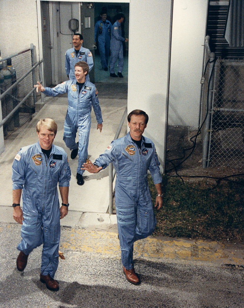 Robert 'Hoot' Gibson (right) and George 'Pinky' Nelson lead the 61C crew out of the Operations & Checkout Building for launch. Following is crewmate Steve Hawley. Photo Credit: NASA