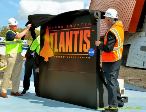 Former NASA shuttle astronaut Jon McBride (far left) along with the Kennedy Space Center Visitor Complex's Chief Executive Officer, Bill Moore, unveil the new sign in front of shuttle Atlantis' exhibit. Photo Credit: Julian Leek / Blue sawtooth Studio