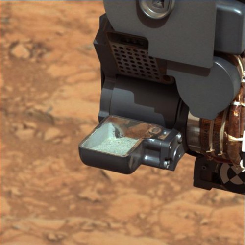 This image from NASA's Curiosity rover shows the first sample of powdered rock extracted by the rover's drill. The image was taken after the sample was transferred from the drill to the rover's scoop. Photo Credit: JPL/NASA
