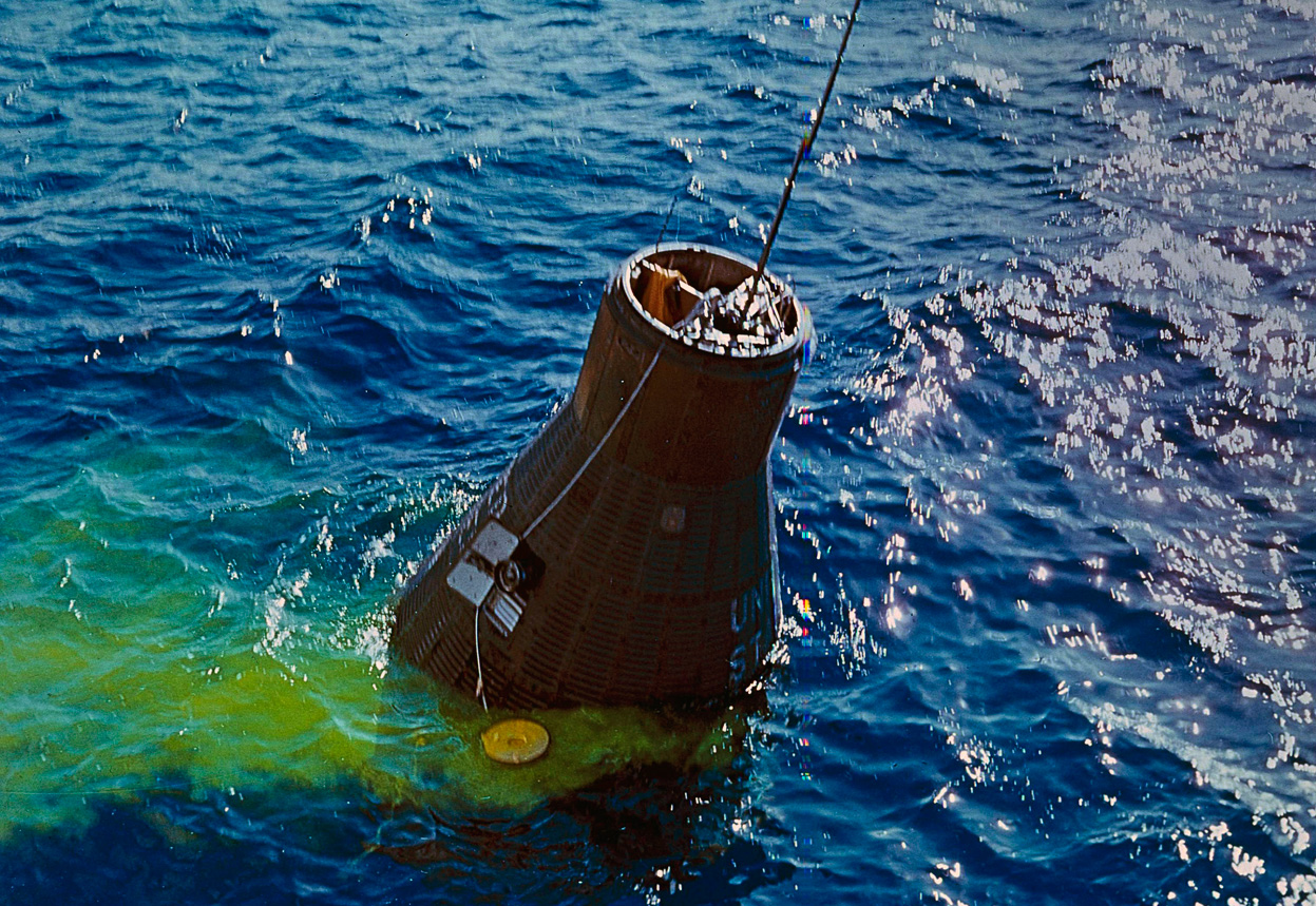 Bobbing gently in the waves after a highly successful - though nail-bitingly harrowing - mission, Friendship 7 is readied for winching out of the water. Photo Credit: NASA