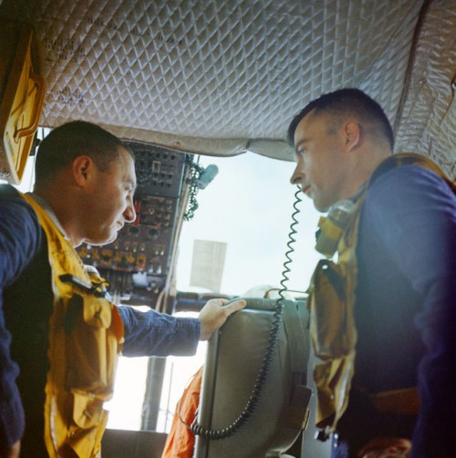 Aboard a recovery helicopter after their splashdown on 23 March 1965, Gus Grissom (left) became the first man to record two space missions and John Young concluded the first flight in one of the most dramatic space careers of all time. Photo Credit: NASA