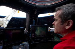 Today's effort to capture and berth the CRS-2 Dragon craft was conducted from within the multi-windowed cupola. Here, Chris Hadfield gazes wistfully outside during work with Canadarm2. Photo Credit: NASA