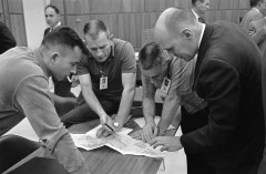 John Young, Gus Grissom and Tom Stafford, together with Deke Slayton (second from left) study orbital-track charts before the launch of Gemini 3. Photo Credit: NASA