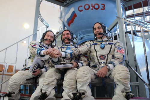 Pictured before qualification simulator runs at the Gagarin Cosmonaut Training Centre, near Moscow, Soyuz TMA-08M crewmen (from left) Aleksandr Misurkin, Pavel Vinogradov and Chris Cassidy clasp hands. Photo Credit: NASA
