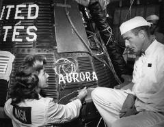 Chrysler artist Cece Bibby chats with Scott Carpenter, after stencilling the name "Aurora 7" onto his spacecraft. Photo Credit: NASA