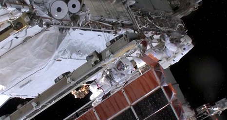 Chris Cassidy (with red stripes) and Tom Marshburn work outside the International Space Station to track down and rectify an anomalous ammonia leak. Photo Credit: NASA