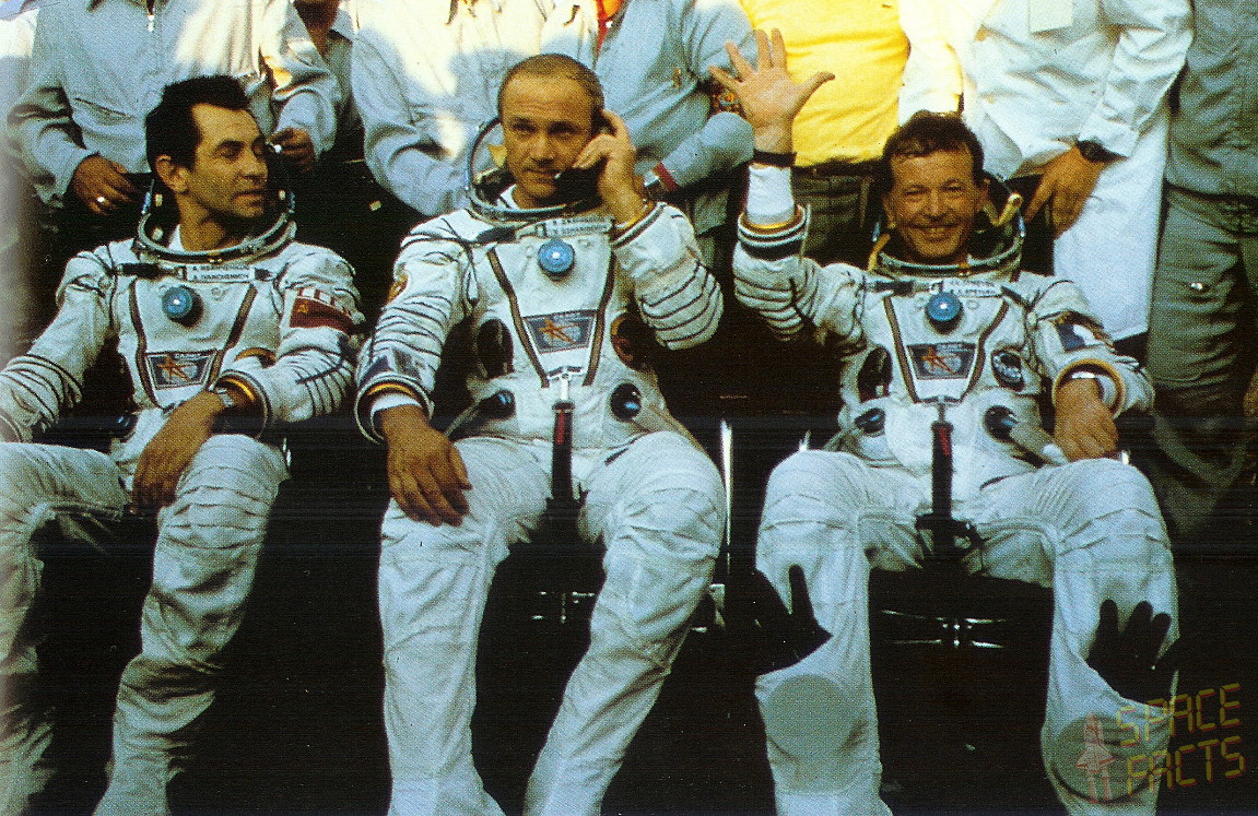 Jean-Loup Chretien (right) waves to well-wishers in the aftermath of his safe landing. Commander Vladimir Dzhanibekov (center) reports by telephone the flight's successful completion, whilst Aleksandr Ivanchenkov looks on. Photo Credit: SpaceFacts.de/Joachim Becker 