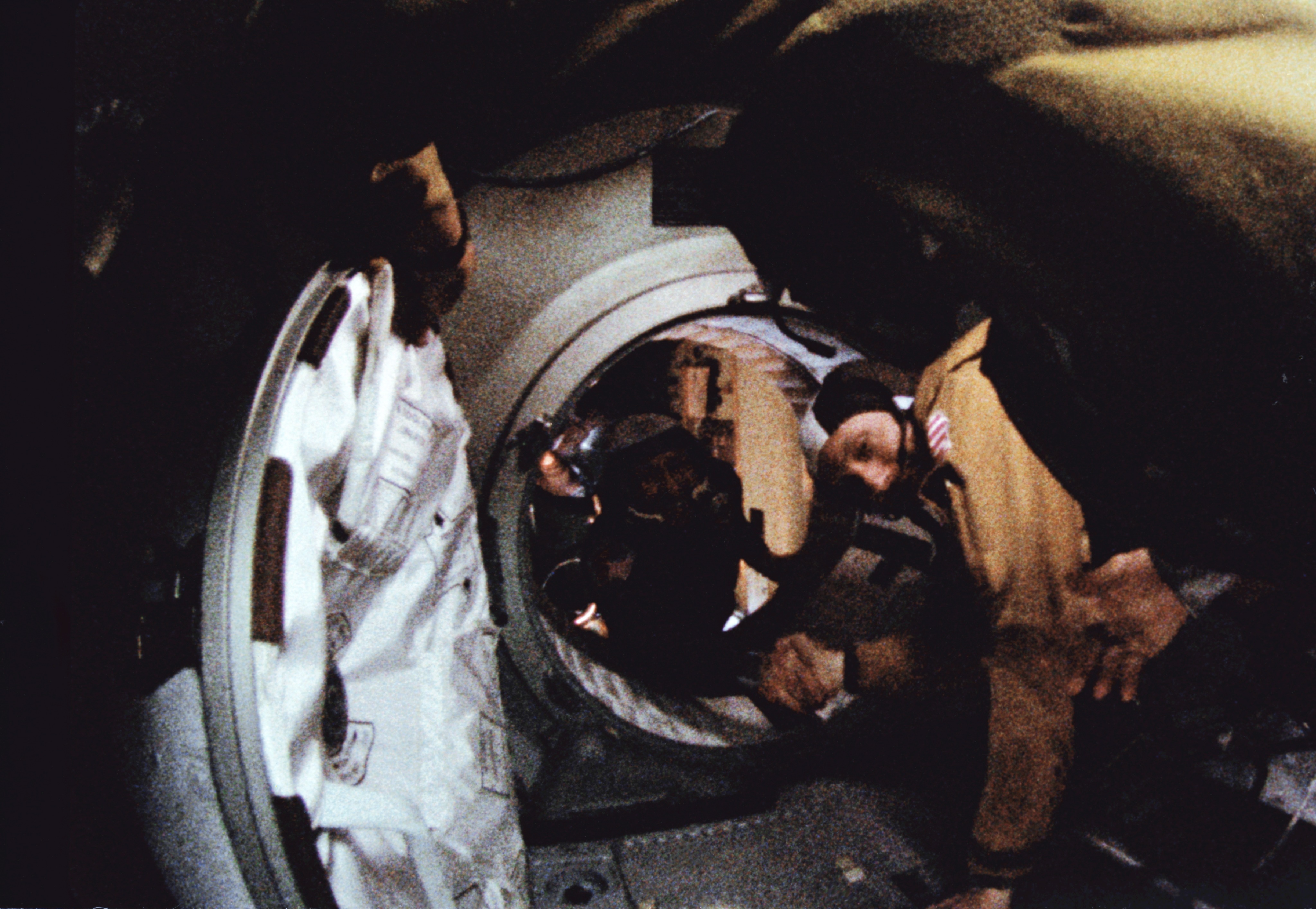 Tom Stafford (right) shakes hands with his counterpart Alexei Leonov in the docking module tunnel on 17 July 1975. This grainy image represents the first serious effort at co-operation between the United States and Russia in human space exploration. Photo Credit: NASA