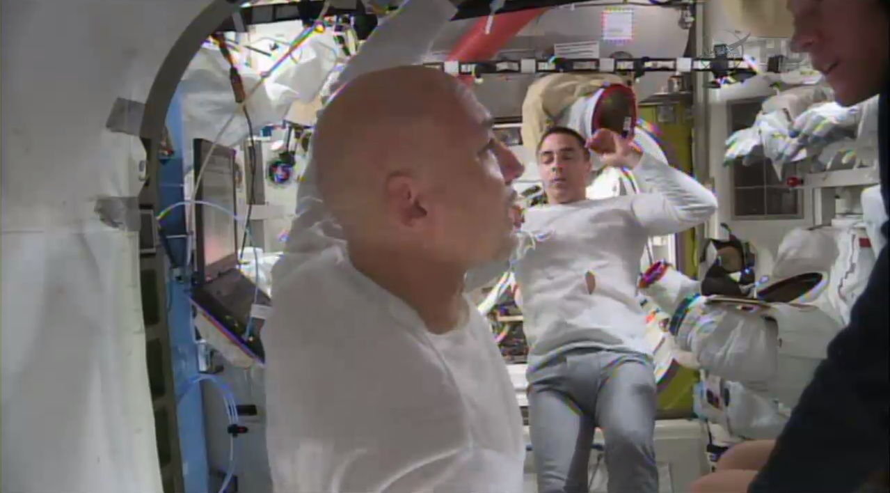 Luca Parmitano (left) confers with Karen Nyberg, as Chris Cassidy looks on, shortly after concluding their 92-minute EVA-23. Photo Credit: NASA TV