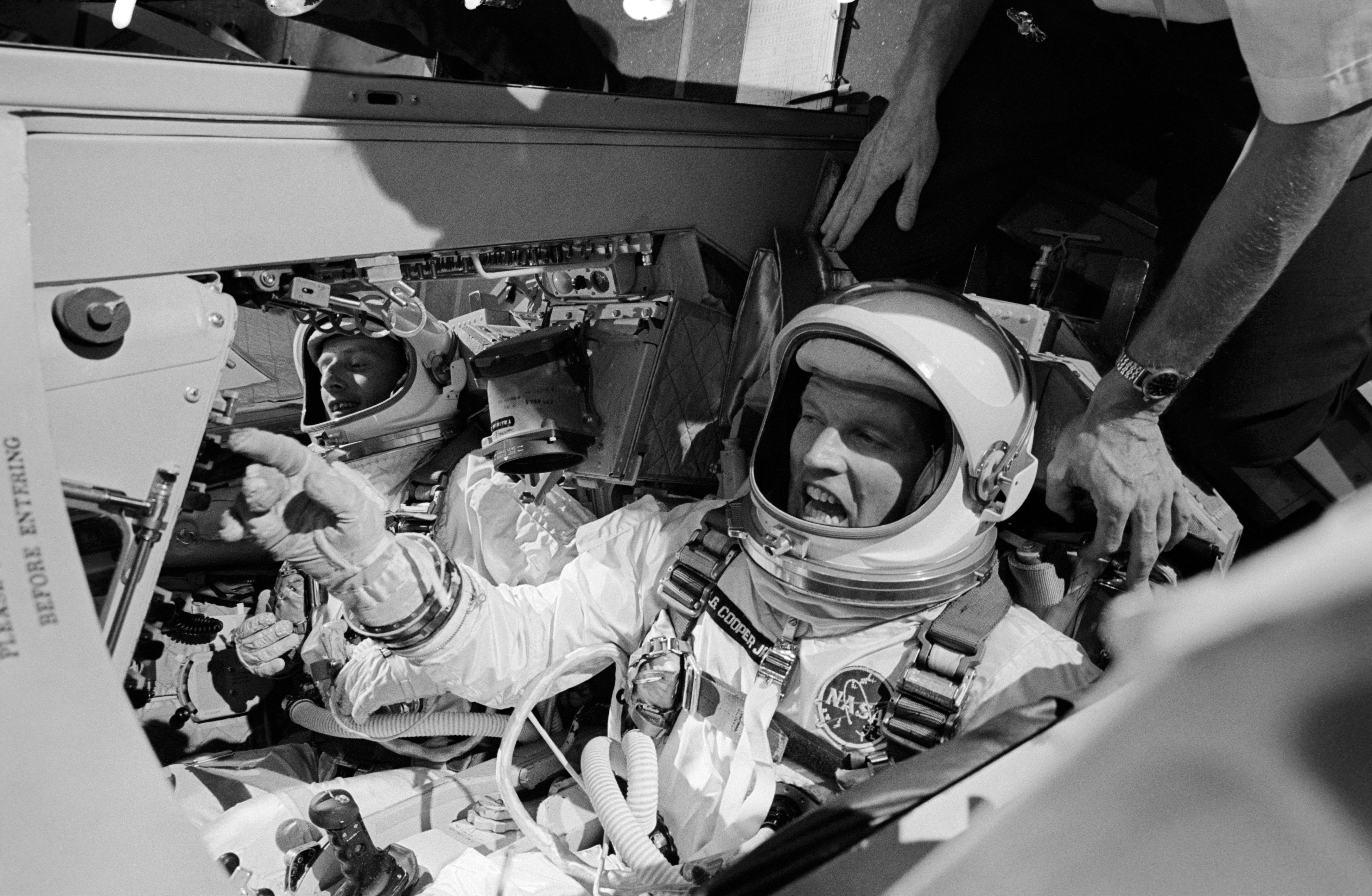 Illustrating the cramped nature of their eight-day home, astronauts Pete Conrad (background) and Gordo Cooper are in jubilant spirits ahead of their 21 August 1965 launch. Photo Credit: NASA
