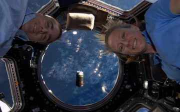Chris Cassidy and Karen Nyberg pose at the windows of the cupola with HTV-4 visible in the background, shortly before initial capture. Photo Credit: NASA