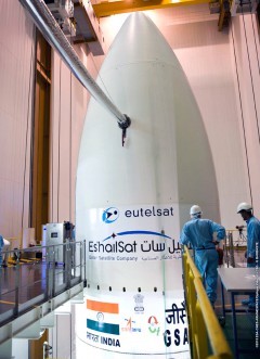 In one of the final moves ahead of launch, the logos for Eutelsat 25B/Es'hail-1 and GSAT-7 are affixed to the VA-215 payload fairing at the Guiana Space Centre in Kourou, French Guiana. Photo Credit: Arianespace 