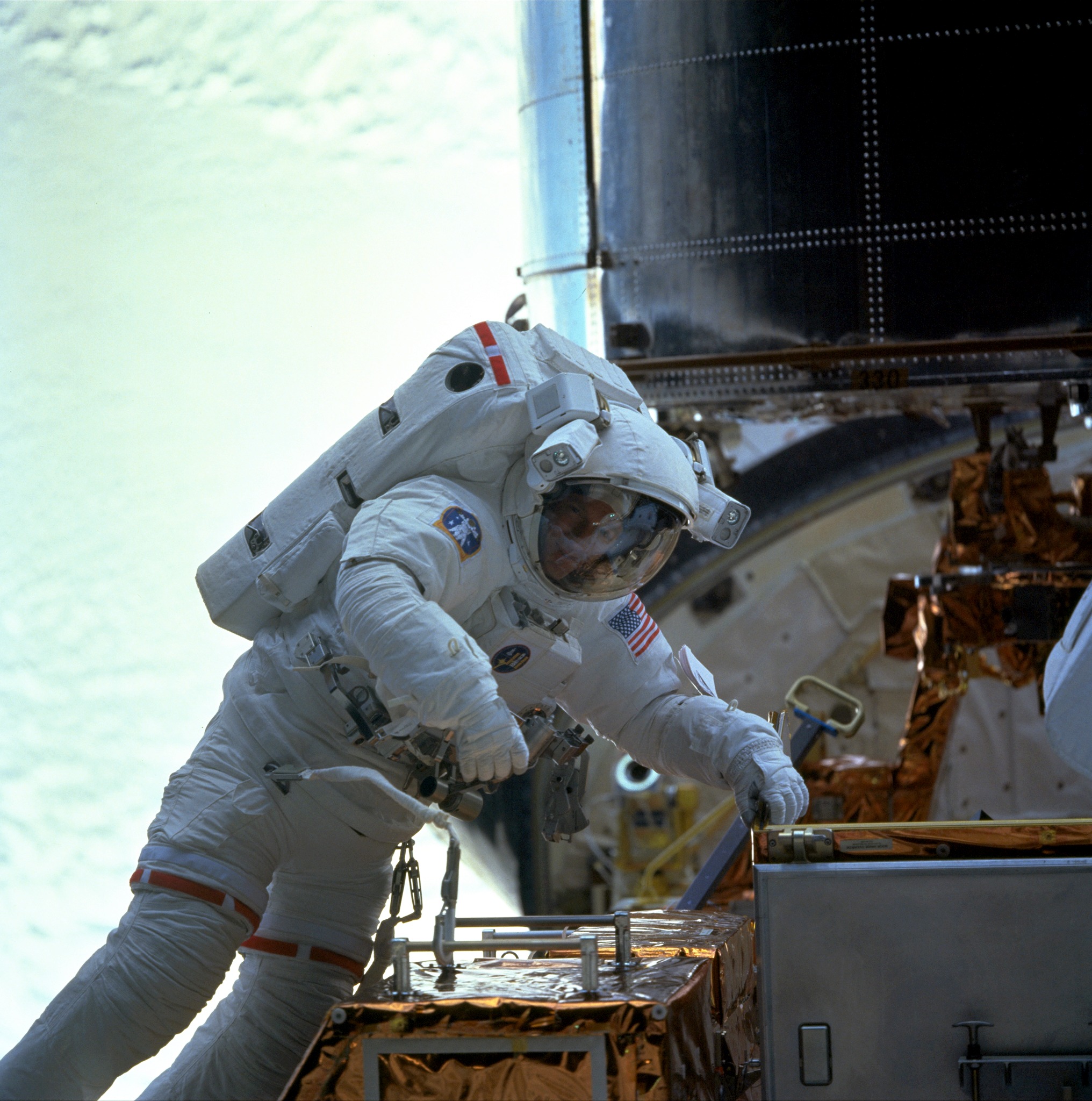 Mike Foale works on the Hubble Space Telescope during the STS-103 servicing mission in December 1999. This was the first and only Shuttle flight to remain in orbit over Christmas. Photo Credit: NASA