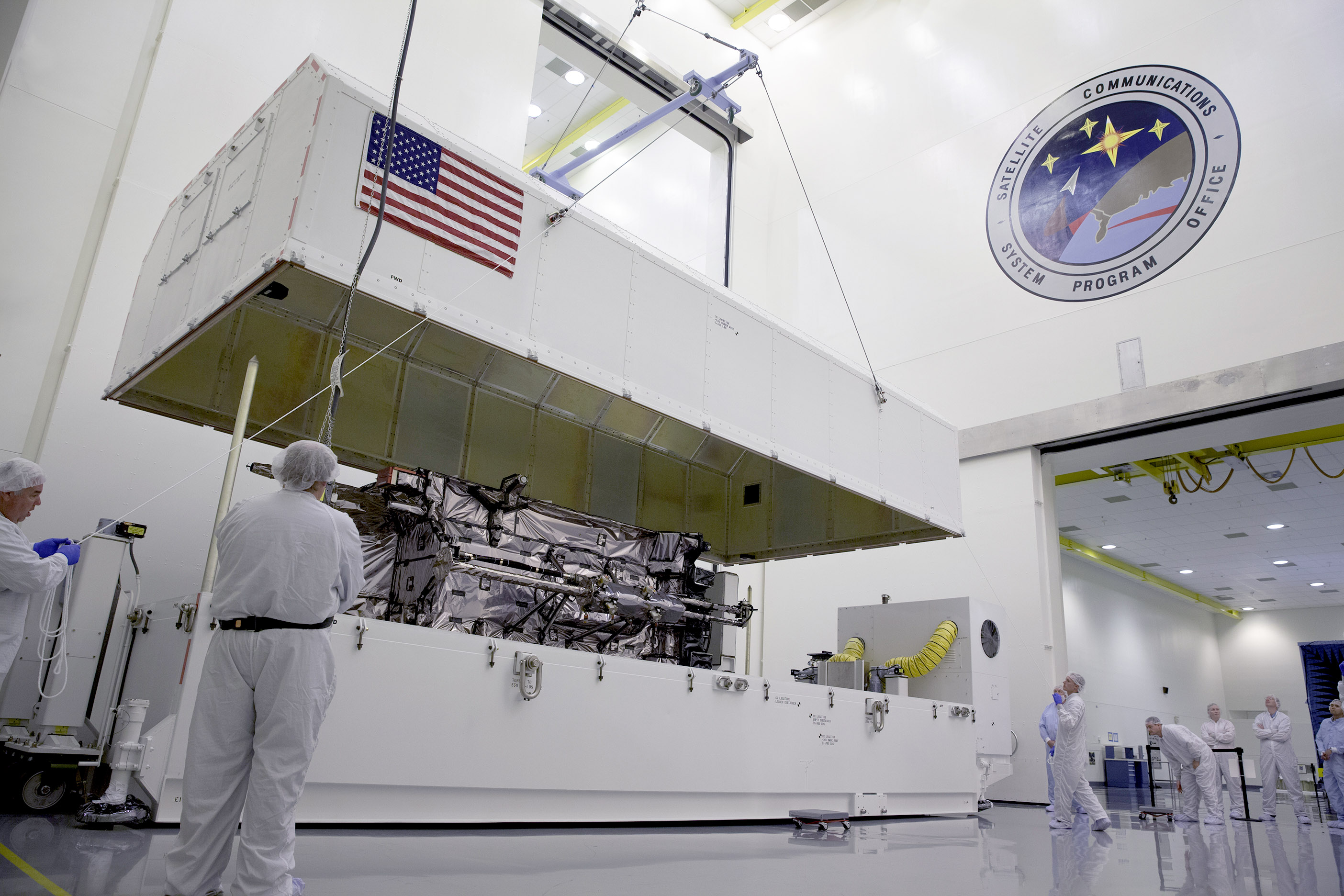 Workers inspect Lockheed Martin's GPS III Non-Flight Satellite Testbed (GNST) after its arrival in July at Cape Canaveral. Photo Credit: Lockheed Martin. Posted by AmericaSpace. 