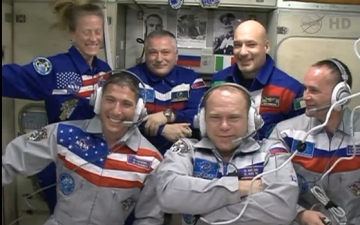 Clad in grey flight suits, Soyuz TMA-10M crewmen (left to right) Mike Hopkins, Oleg Kotov and Sergei Ryazansky are greeted by their blue-garbed Expedition 37 colleagues Karen Nyberg, Fyodor Yurchikhin and Luca Parmitano after hatch opening. Photo Credit: NASA