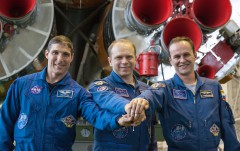 Standing in front of the first stage engines of their Soyuz rocket on 20 September 2013, Soyuz TMA-10M crewmen (left to right) Mike Hopkins, Oleg Kotov and Sergei Ryazansky clasp hands in solidarity. Photo Credit: NASA