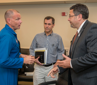 Astronaut Anthony Antonelli, SLS Program PDR Board crew office representative, talks with other PDR Board members Tony Lavoie, SLS Stages Manager, and Todd May, left, SLS program manager, after the certificate was signed.