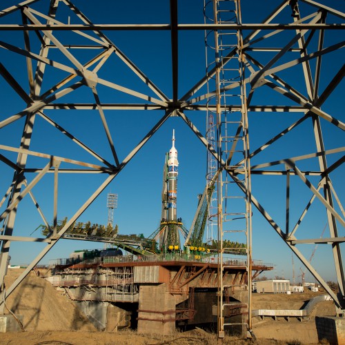 Unusual perspective of the Soyuz TMA-11M vehicle in a vertical configuration atop the pad complex at Baikonur. Photo Credit: NASA