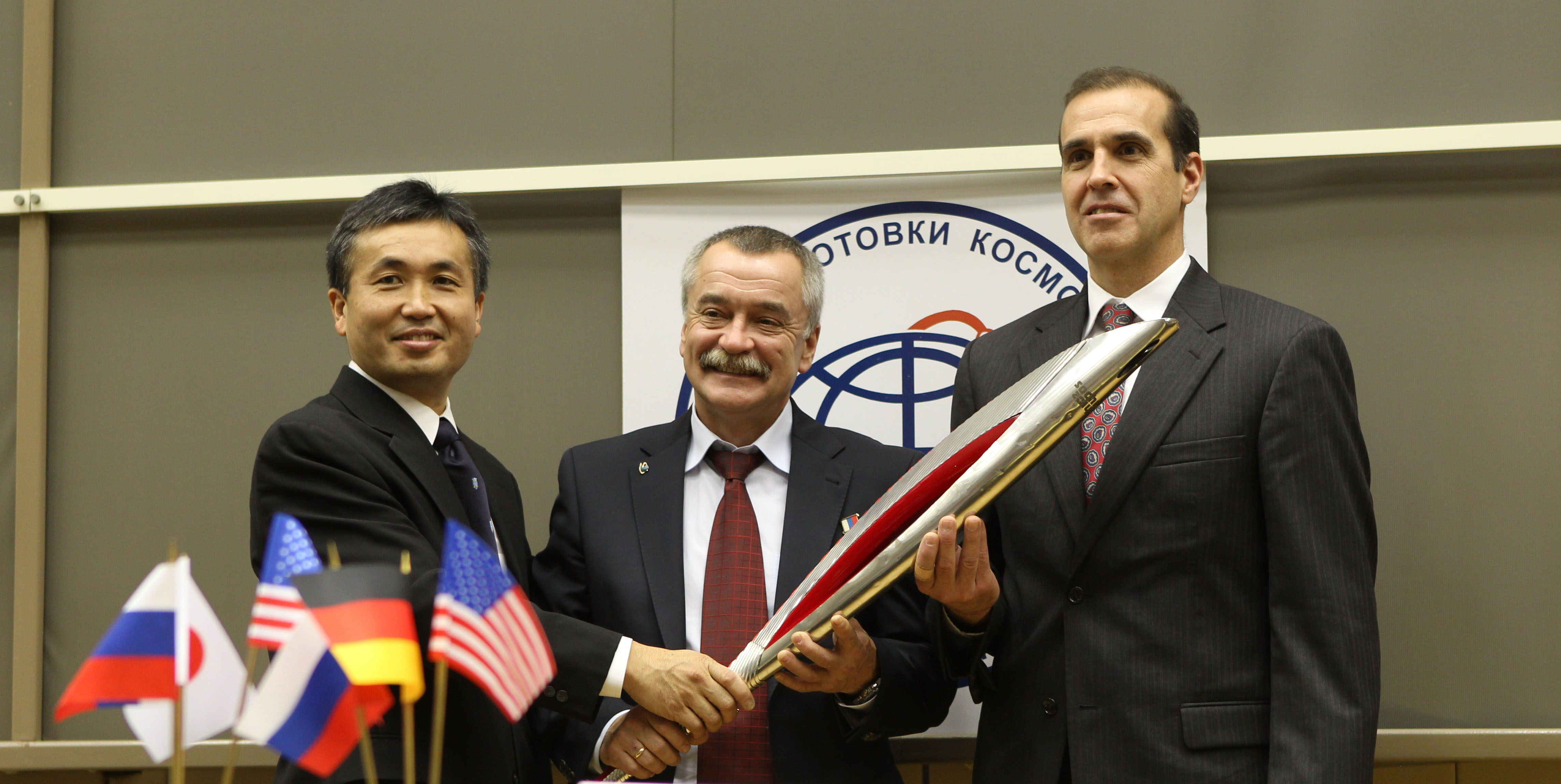 Koichi Wakata, Mikhail Tyurin and Rick Mastracchio proudly display the modified Olympic torch during a pre-flight press conference. Photo Credit: NASA