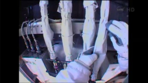 Rick Mastracchio's gloved hands tend to the demating of one of the four ammonia fluid quick disconnects (QDs) during Saturday's EVA-24. Photo Credit: NASA TV/Leonidas Papadopoulos