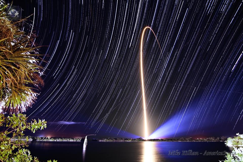 The rotation of the Earth captured in the trails of the stars over Cape Canaveral Air Force Station last Thursday night. NASA's latest Tracking & Data Relay Satellite, TDRS-L, is seen here hitching a fiery ride to orbit atop an Atlas-V rocket, as viewed from the Turn Basin on Kennedy Space Center just a few miles away.  Photo Credit: AmericaSpace / Mike Killian