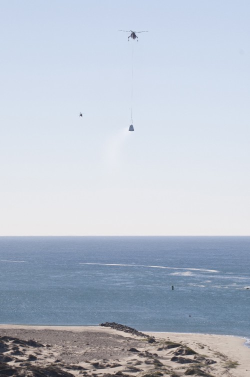 An Erickson Sky Crane helicopter returns the SpaceX Dragon test article to Morro Bay, Cailf., following a drop test to evaluate the spacecraft's parachute deployment system. Photo Credit: NASA/Kim Shiflett