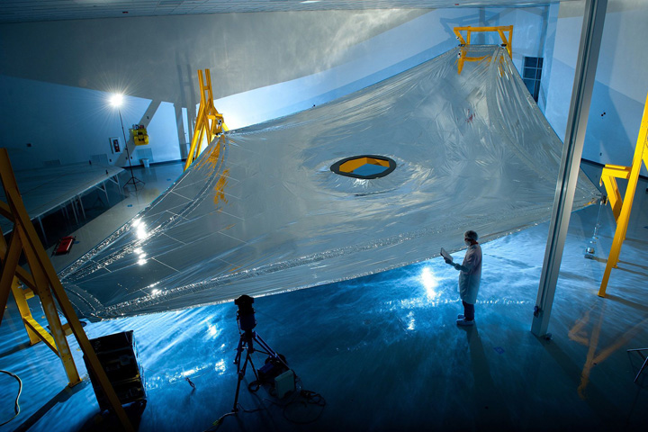A full-scale JWST sunshield membrane deployed on the membrane test fixture at Mantech, Hunstville, ready for a precise measurement of its three dimensional shape. The JWST sunshield comprises five of these layers, each of which has to be precisely spaced with respect to the next. Photo Credit: Northrop Grumman Aerospace Systems
