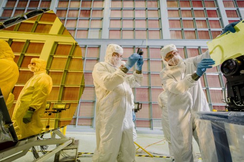 Technicians perform a contamination inspection on the James Webb Space Telescope Primary Mirror Segment Array (PMSA) Engineering test unit (ETU) using a long distance microscope. Credit: NASA/Chris Gunn