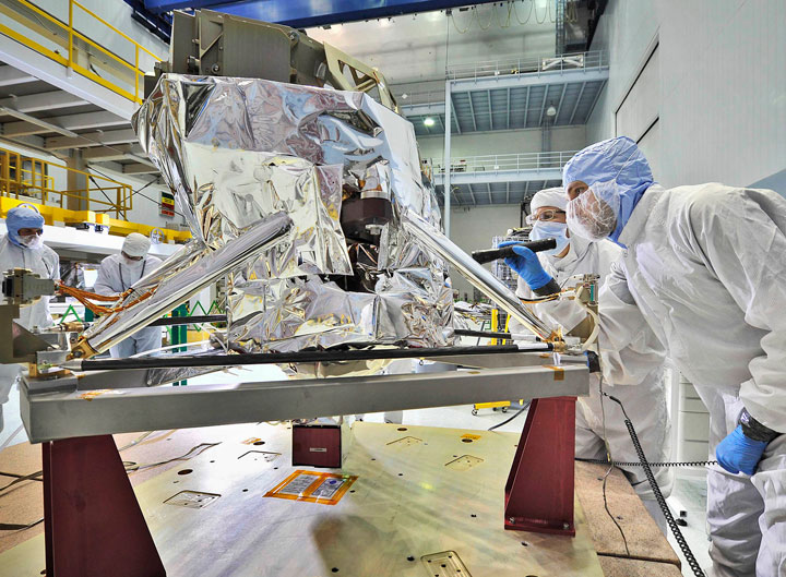Contamination control engineers conducted a "receiving inspection" of the James Webb Space Telescope's Mid-Infrared Instrument (or MIRI) in the giant clean room at NASA's Goddard Space Flight Center in Greenbelt, Md. and gave it a clean bill of health after its transatlantic journey from the U.K. Jose Lorenzo, MIRI Instrument Manager/onsite European Space Agency representative (in the blue hood) is shown holding a flashlight. Standing beside him (wearing a white hood) is Eve Wooldridge, NASA Goddard engineer. As part of the standard receiving inspection, they are looking for the tiniest traces of dust or contamination which would have to be remedied because cleanliness is a priority for such a sensitive instrument. Credit: NASA/Chris Gunn
