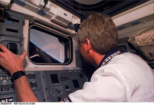 Pictured on Discovery's aft flight deck at the RMS controls, Steve Hawley was making his fourth shuttle flight. He was the only member of the original HST deployment crew to fly on a subsequent servicing mission. Photo Credit: NASA