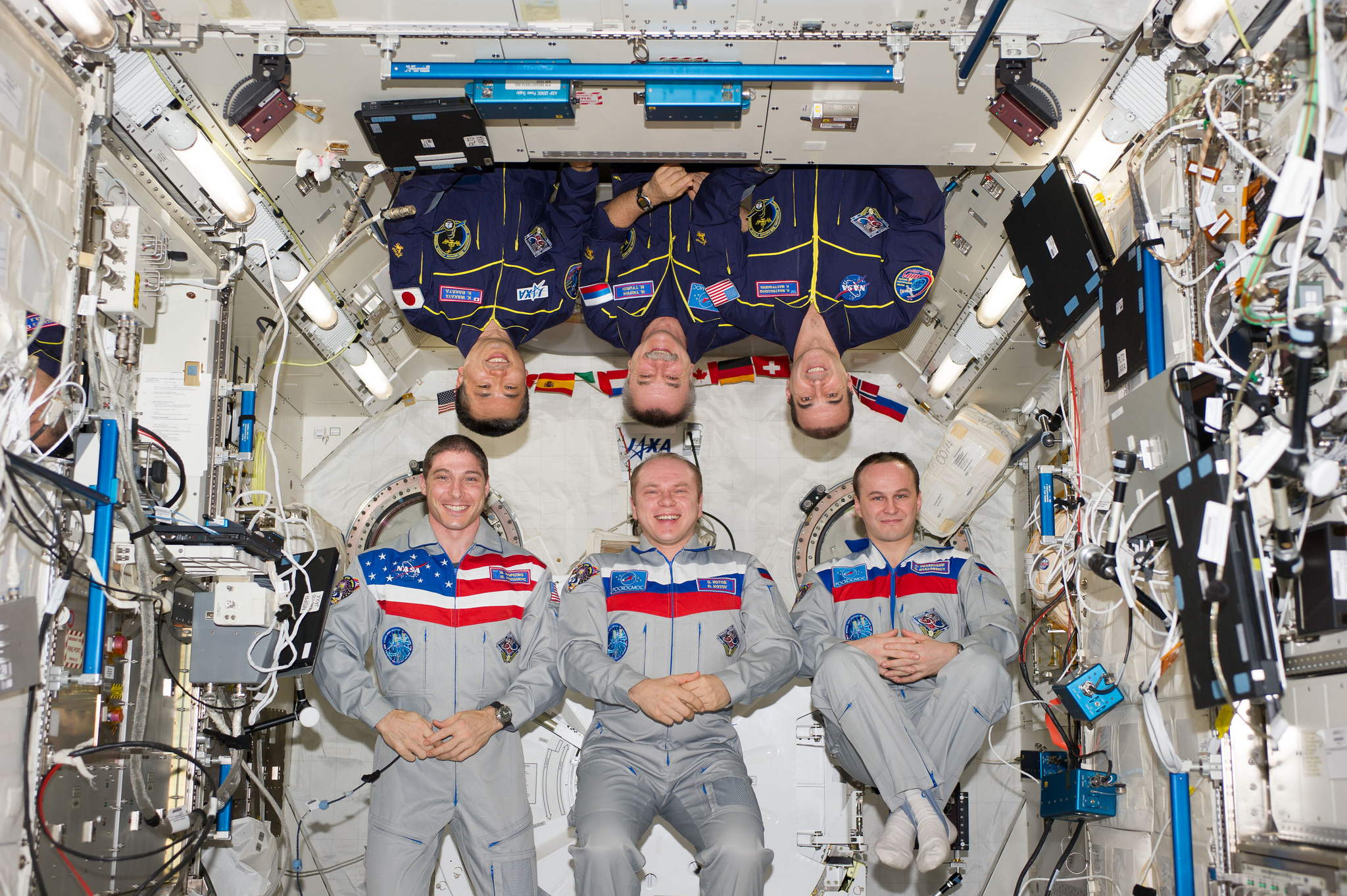 Outgoing Expedition 38 crewmen (bottom row, left to right) Mike Hopkins, Oleg Kotov and Sergei Ryazansky) are pictured with their new Expedition 39 comrades (top row, left to right) Koichi Wakata, Mikhail Tyurin and Rick Mastracchio. The two crews have worked together as members of Expedition 38 since November 2013. Now, Wakata will lead the station until mid-May. Photo Credit: NASA