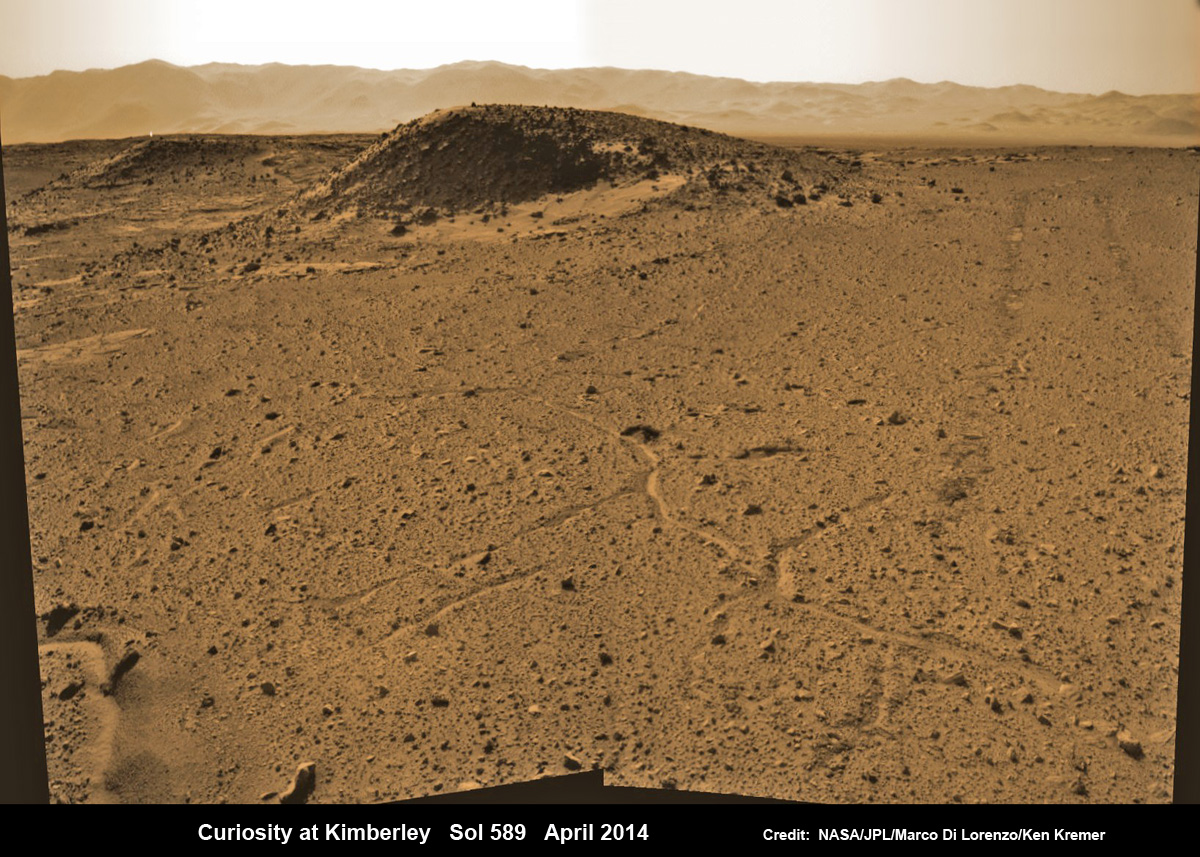 Curiosity maneuvers into ‘Kimbeley’ and scans scientifically intriguing Martian rock outcrops in search of next drilling location exhibiting several shallow hills in foreground and dramatic Gale crater rim backdrop.  Rover tracks at right in this colorized Navcam photomosaic assembled from raw images snapped on Sol 589, April 3, 2014. Credit: NASA/JPL/Marco Di Lorenzo /Ken Kremer - kenkremer.com